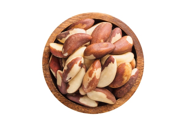 Brazilian nuts peeled in wooden bowl isolated on white background Vegan food top view