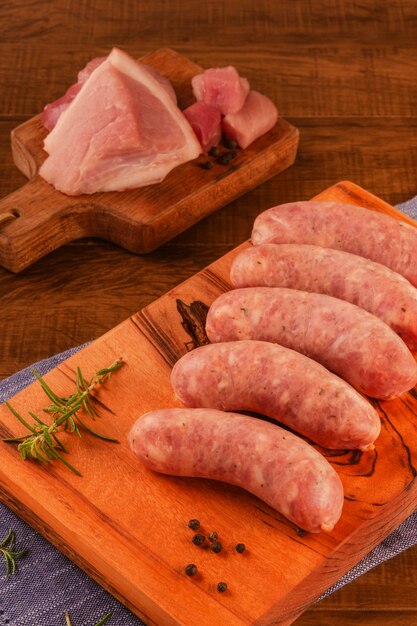 Brazilian pork leg sausage on wood cutting board with pork leg isolated on wood