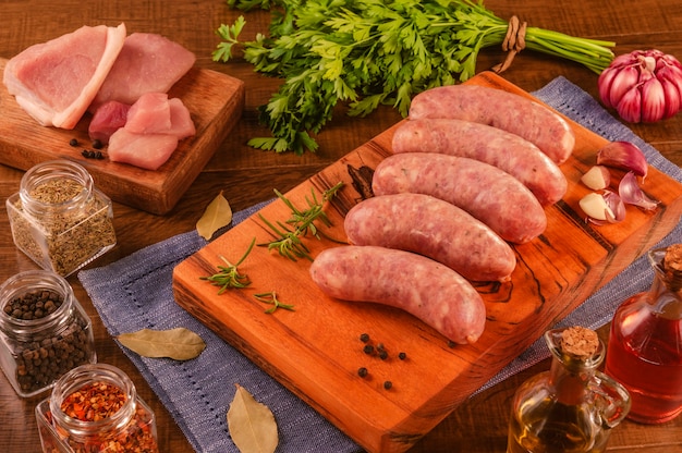 Brazilian pork leg sausage on wood cutting board with spices and ingredients