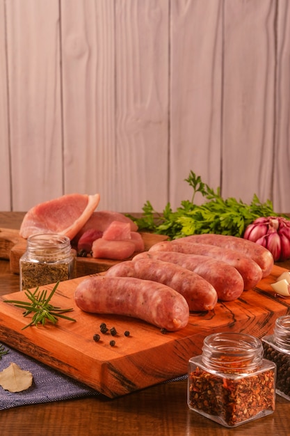 Brazilian pork leg sausage on wood cutting board with spices and ingredients
