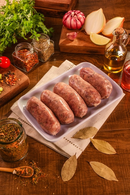 Brazilian pork sausage with chimichurri on white plate with spices and ingredients