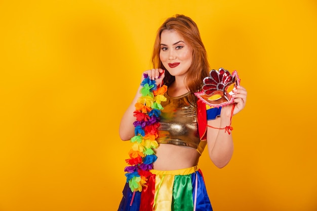 Brazilian redhead with carnival clothes frevo and colorful parasol holding mask and flower necklace