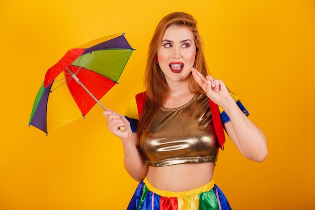 Brazilian redhead with carnival clothes frevo and colorful parasol wishing cheering