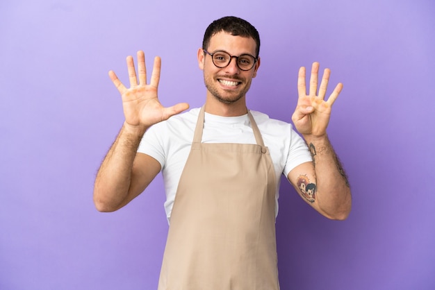 Brazilian restaurant waiter over isolated purple background counting nine with fingers