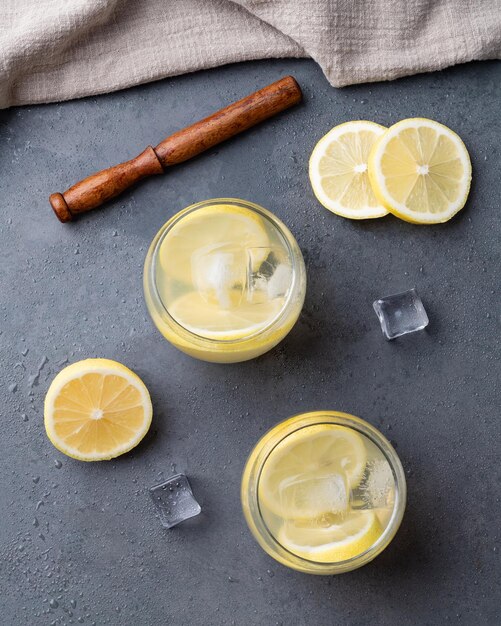 Brazilian sicilian lemon caipirinha in glasses with ice and fruit slices over stone background