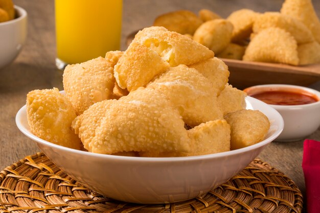 Brazilian snack, with a bar in the background. Cheese pastry on wooden background.