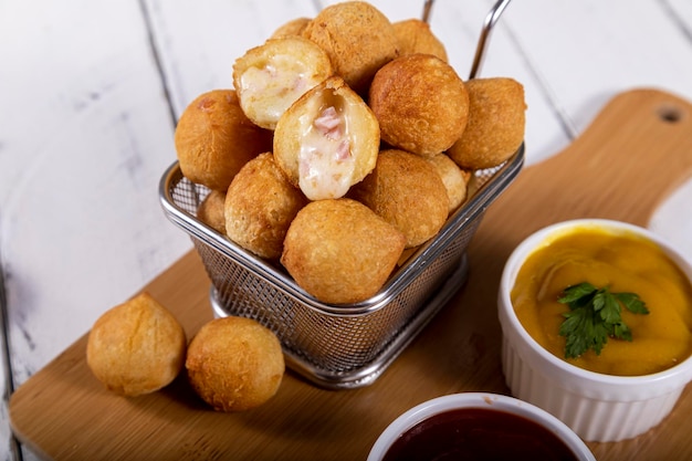 Brazilian snacks fried balls stuffed with ham and cheese Selective focus