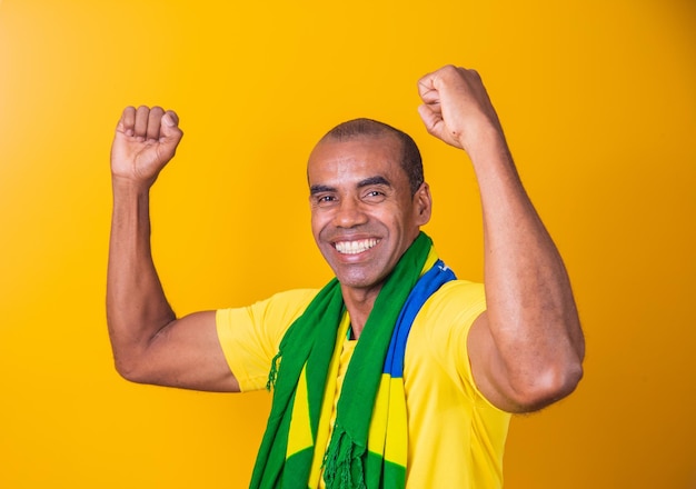 黄色の背景で祝うブラジルのサッカー選手xA