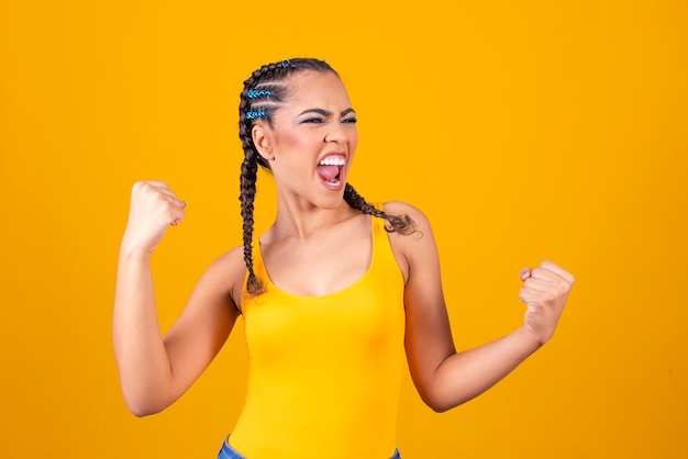 Brazilian supporter brazilian woman fan celebrating on soccer or football match on grey background brazil colors