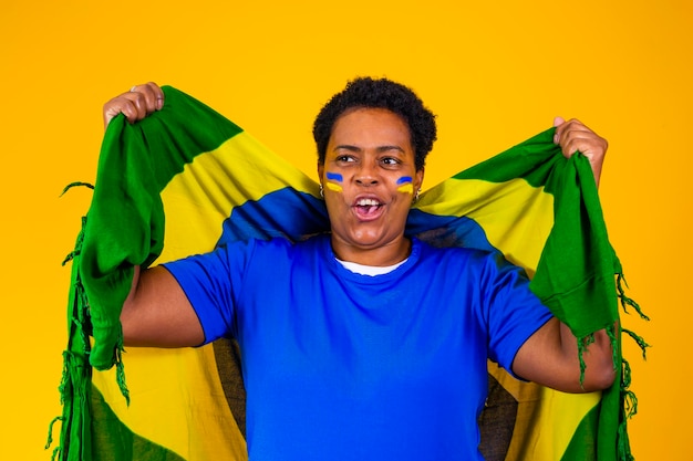Бразильская болельщица Бразильская фанатка празднует футбол или футбольный матч на желтом фоне Цвета Бразилии