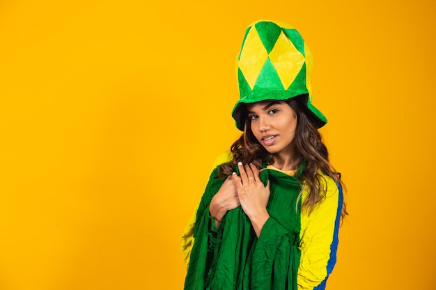 Brazilian supporter. brazilian woman fan celebrating on soccer or football match on yellow background. brazil colors