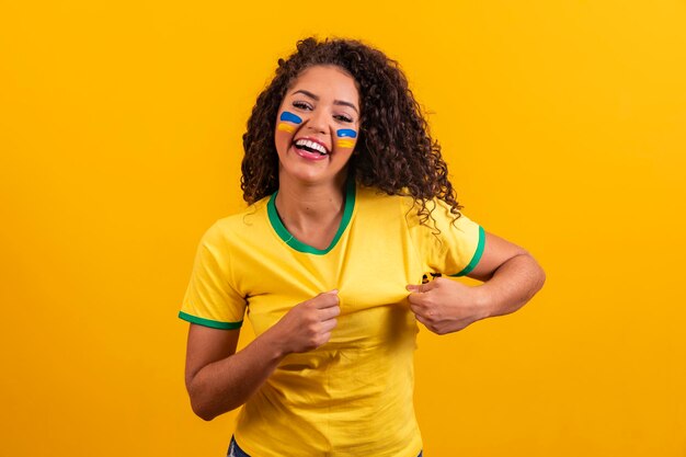 Brazilian supporter brazilian woman fan celebrating on soccer or football match on yellow background brazil colorsxa