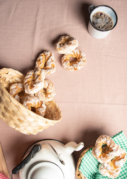 Фото Бразильское сладкое печенье и чашка кофе на столе с бежевой скатертью, выборочный фокус.