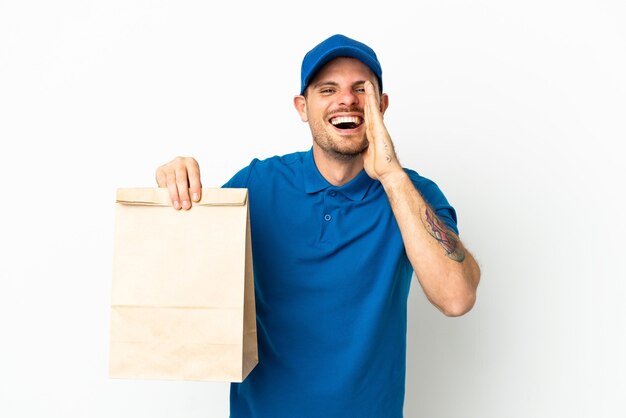 Brazilian taking a bag of takeaway food isolated on white background shouting with mouth wide open