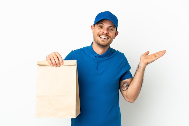 Brazilian taking a bag of takeaway food isolated on white background with shocked facial expression