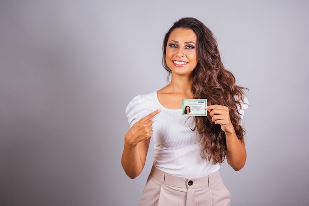 Photo brazilian woman brown hair holding identity card rg brazilian document