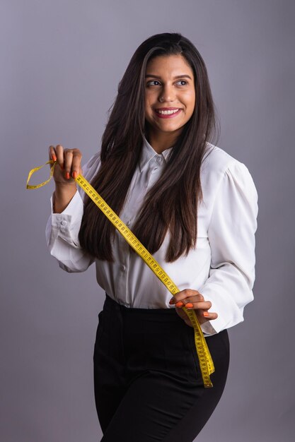 Бразильская женщина-диетолог держит измерительную ленту Вертикальное фото