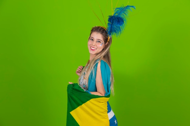 Brazilian woman posing in samba costume on green background with the flag of Brazil