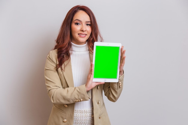 Brazilian woman redhead beautician beauty professional presenting tablet with Chroma screen