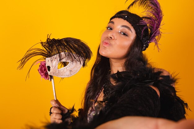 Brazilian woman wearing carnival clothes holding carnival mask