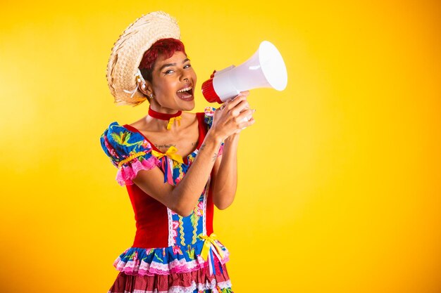 Brazilian woman with festa junina clothes arraial feast of saint john with notebook with megaphone