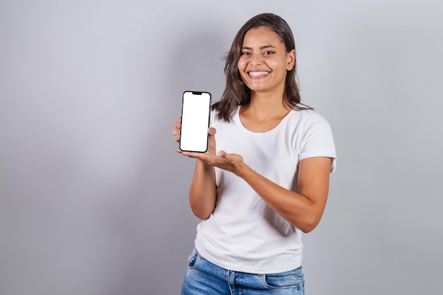 広告や広告の白い画面を表示しているスマートフォンを持つブラジル人女性