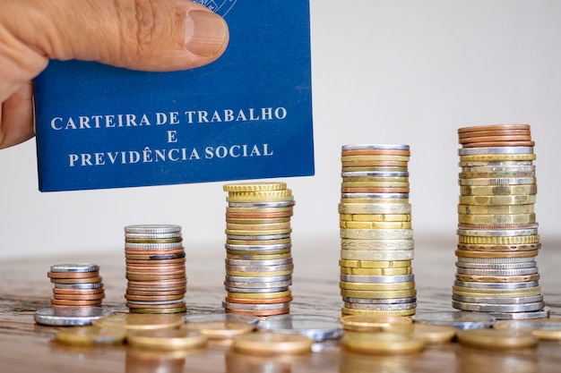 Brazilian Work Card with stacks of coins on the table. Job and economy concept