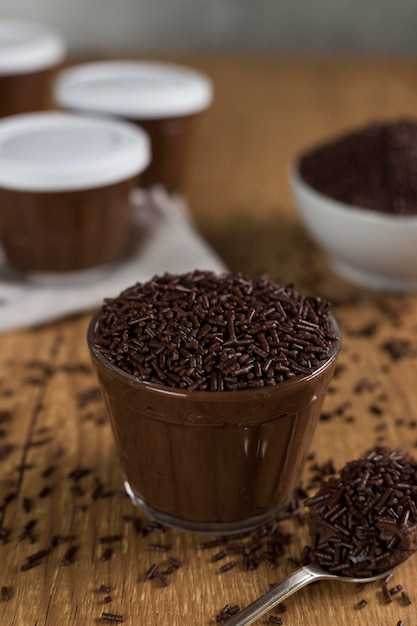 Dolce al cioccolato brasiliano chiamato brigadeiro in vaso su sfondo di legno della scrivania versione vegana