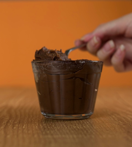 Dolce al cioccolato brasiliano chiamato brigadeiro in vaso su sfondo di legno della scrivania versione vegana