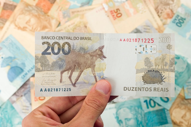 Brazillian Money, man holding 200 Reais notes.