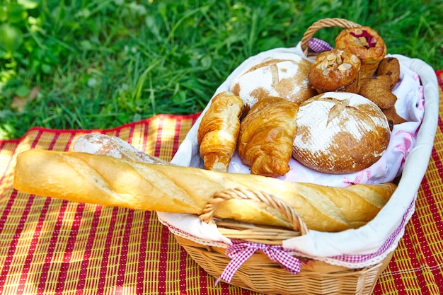 Foto pane, baguette e croissant in un cestino da picnic