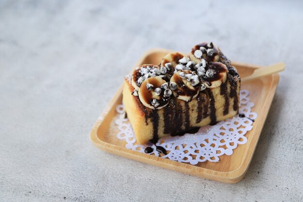 Bread baker toasted with chocolate and banana on wood plate dessert food in coffee shop