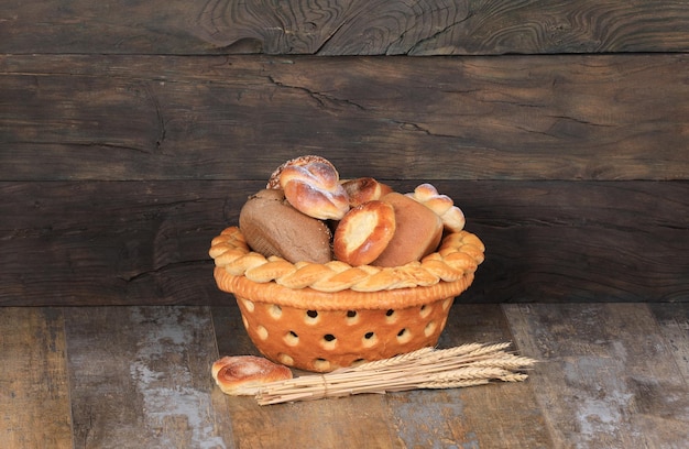木製の背景に甘いパンとパンのバスケット