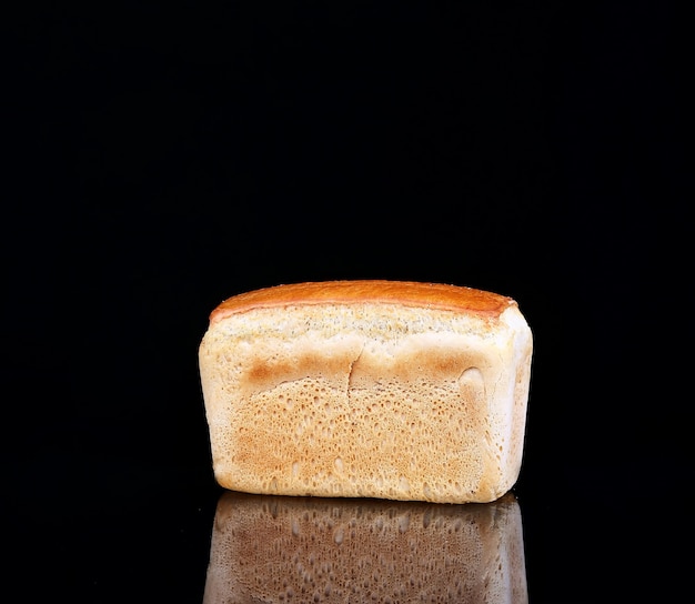 Bread on a black background with reflection