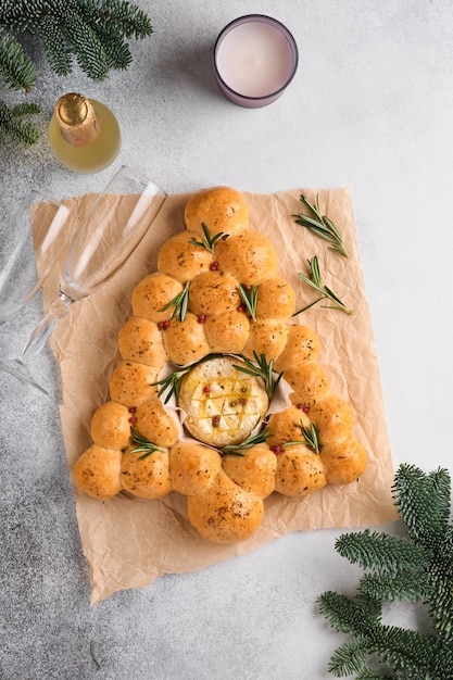 Bread buns Christmas tree with Roasted camembert cheese and rosemary on rustic background Holiday recipes Christmas menu Christmas or Xmas pastries Top view Copy Space