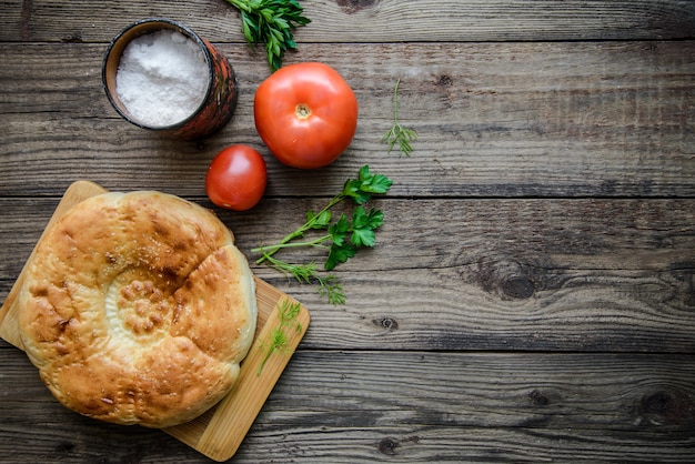 Bread cake and tomatoes on wooden