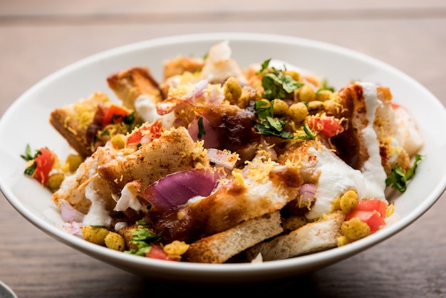 Bread chaat, chat is een lekker voorgerecht of aperitief uit India, geserveerd in een kom gegarneerd met tomaat, sev en koriander en masala. selectieve focus