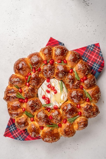 Bread christmas wreath with cheese topped with rosemary and pomegranate