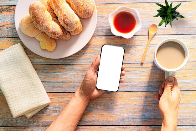 Pane e caffè al mattinovista dall'alto delle mani che bevono al ristorante della caffetteria persone