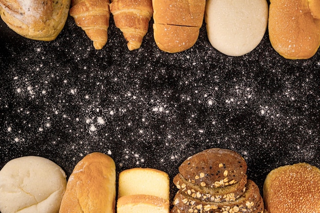 Bread concept loaves of bread buns slices of bread with seeds and croissants arranged