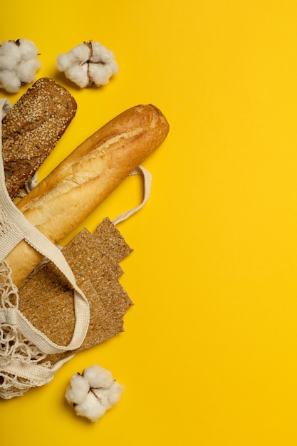 Хлеб в хлопковом экологически чистом пакете на желтой поверхности