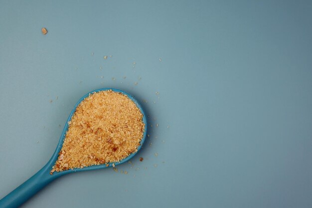 Foto zecche di pane in un cucchiaio blu su uno sfondo blu