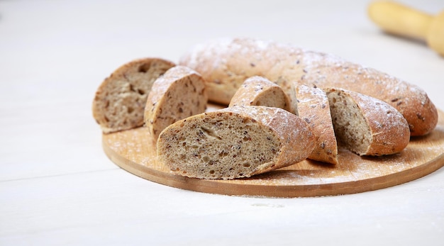 Bread on a cutting Board. Whole-grain rye bread. On light wooden table