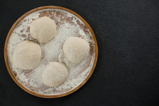 Bread dough ball on a wooden tray