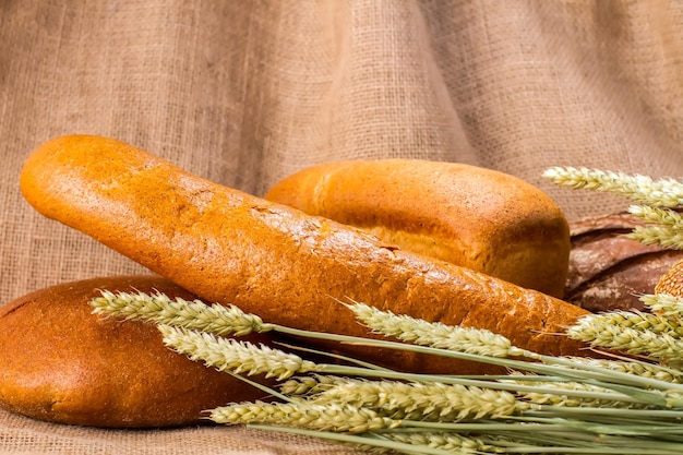 Хлеб и колосья Хлебобулочные изделия, лежащие на ткани Еда, приготовленная с любовью Здоровье начинается с питания