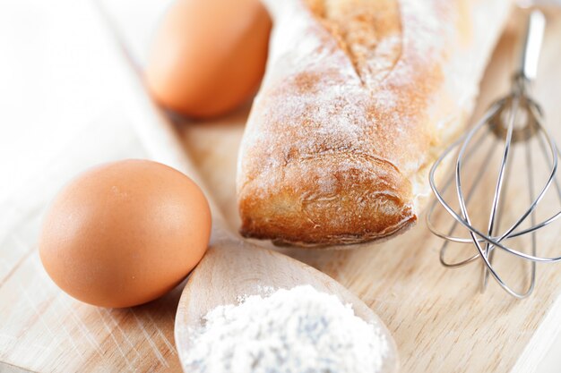 Bread, flour, eggs and kitchen utensil