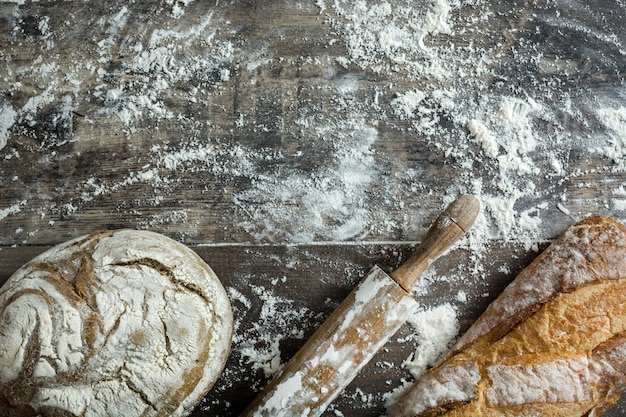 Bread and flour on a rustic wooden background