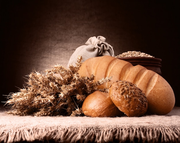 Bread, flour sack and ears bunch still life on rustic