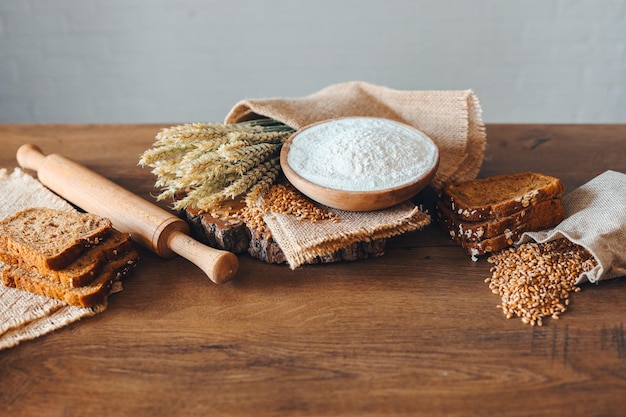 Grani di pane spighe di grano e farina su uno sfondo di legno banner pubblicitario da forno