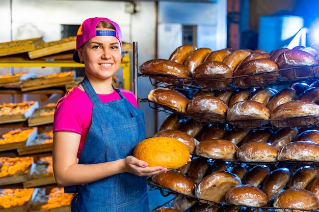 Bread in the hands of a baker on the background of an industrial oven Industrial bread production